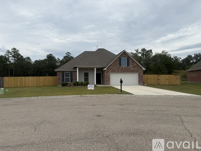 A house with a garage and a sign in front of it.