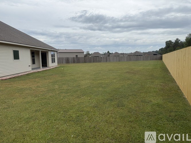A backyard with a fence and a house.