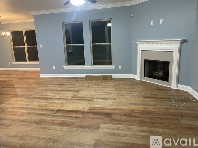 A room with a fireplace and wood flooring.