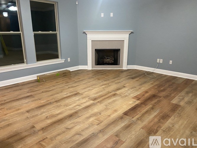 A room with a fireplace and wooden flooring.
