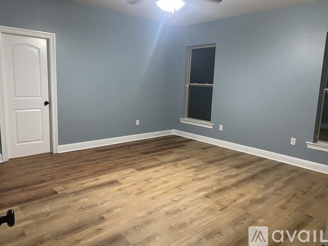 A room with wooden flooring and a door.