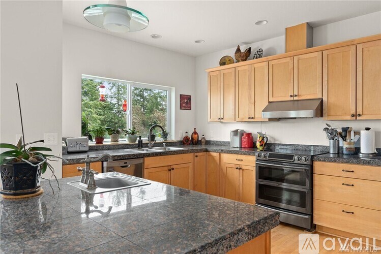 A kitchen with wooden cabinets and granite countertops.