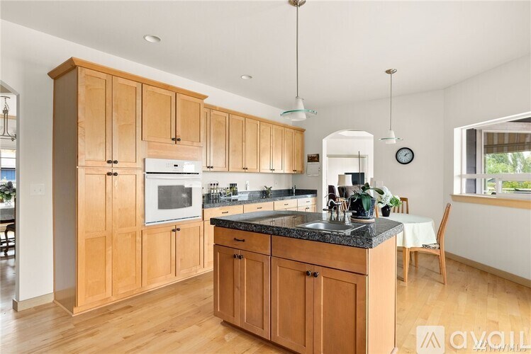 A kitchen with wooden cabinets and a black countertop.