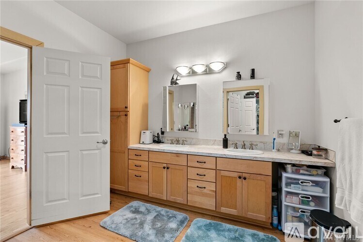 A bathroom with a white door, a mirror, and a sink.