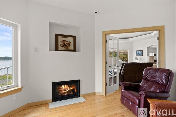 A living room with a fireplace and a purple leather chair.