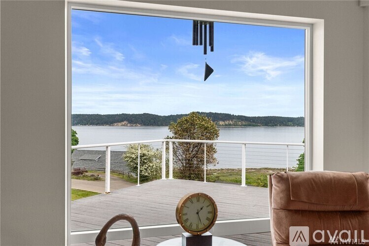 A room with a view of a lake through a large window.