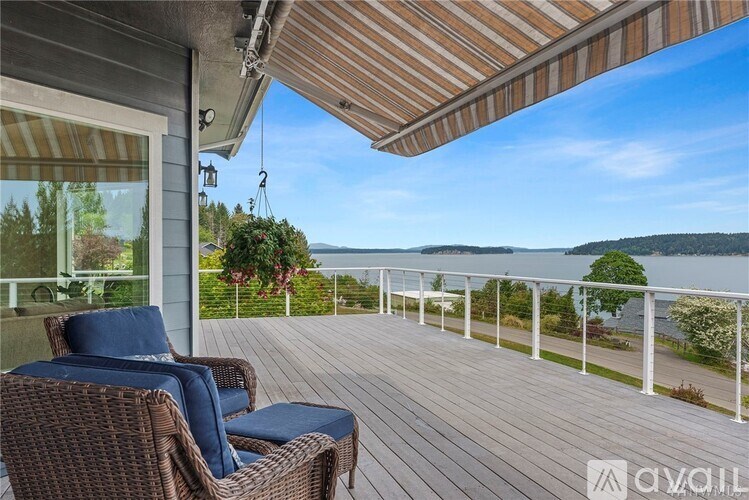 A balcony with a chair and a table overlooking a lake.