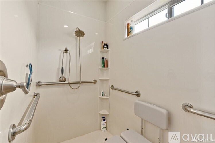A white bathroom with a shower and a toilet.