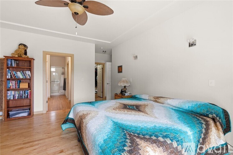 A bedroom with a large bed and a ceiling fan.