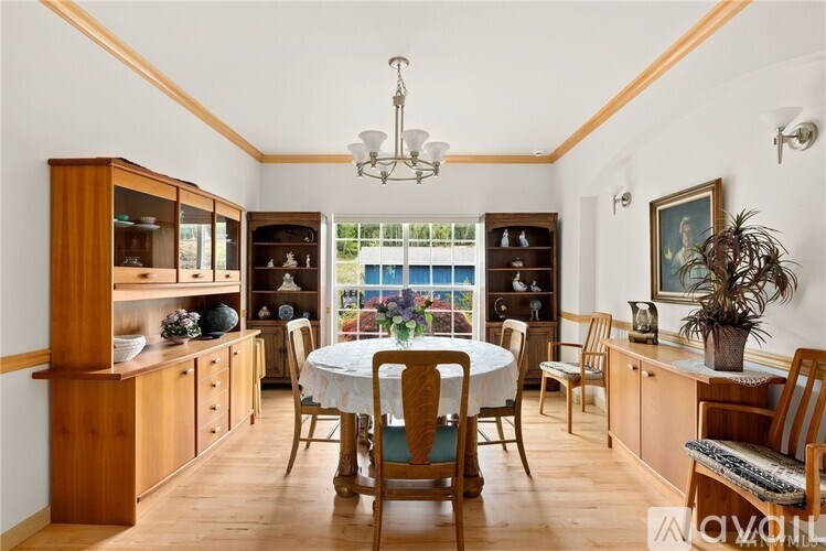 A dining room with a round table surrounded by chairs.