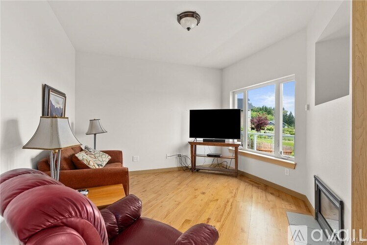 A living room with a red couch and a flat screen TV.