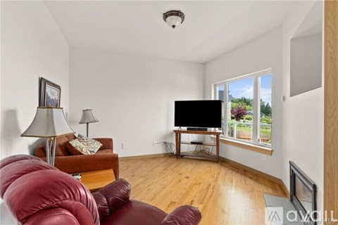 A living room with a red couch and a flat screen TV.