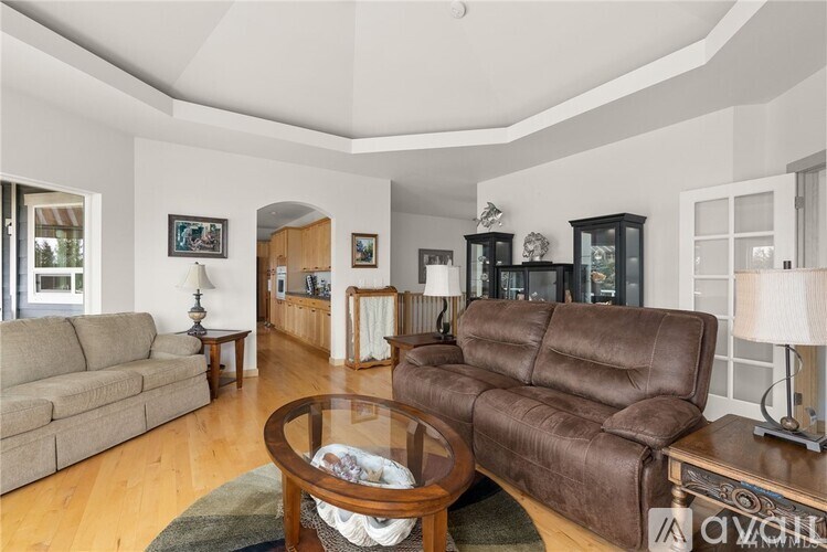 A living room with a brown leather couch and a glass coffee table.