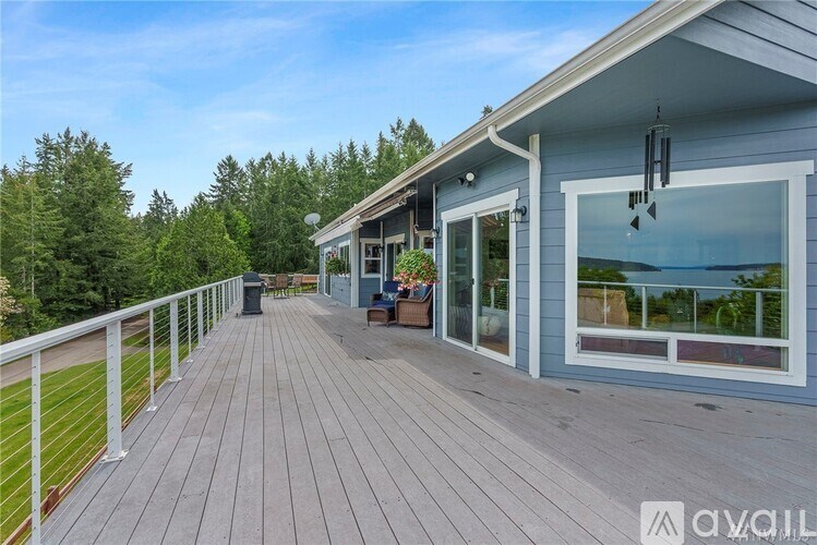 A wooden deck with a white railing and a house in the background.