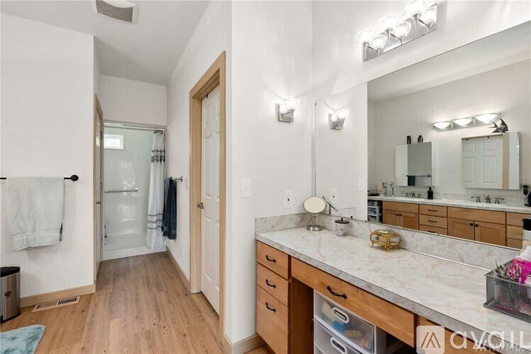 A bathroom with a vanity, mirror, and lights.