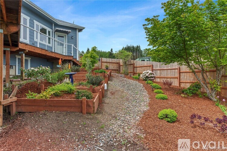 A backyard with a gravel path and a wooden fence.