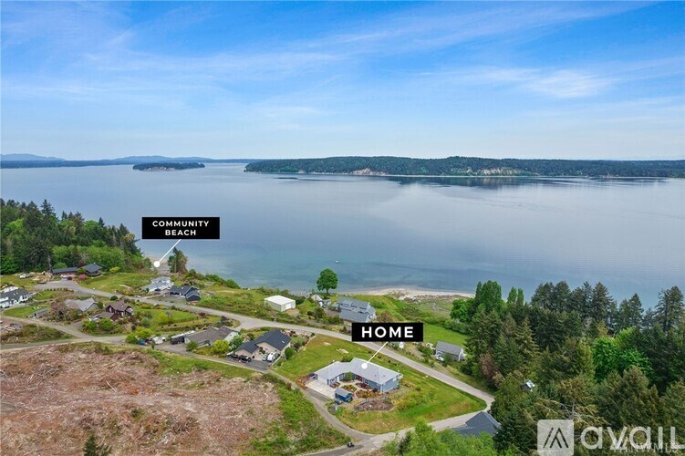 An aerial view of a beachfront property with a community beach in the distance.