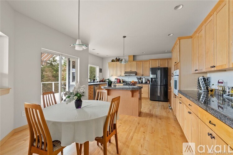 A kitchen with wooden cabinets and a table with chairs.