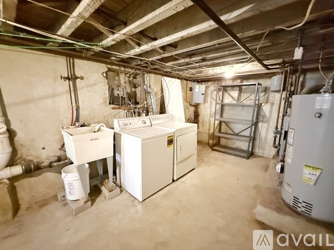 A dirty basement with a washer and dryer.