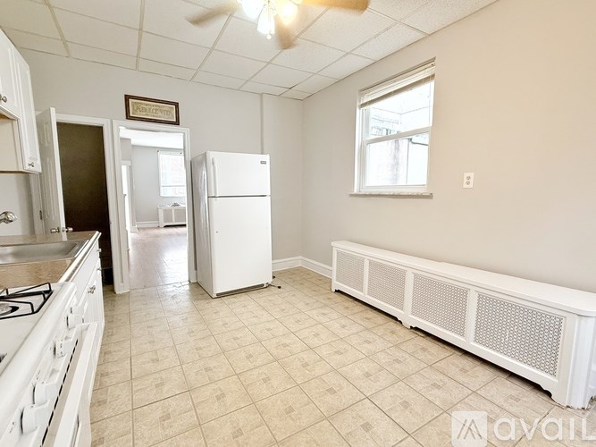 A kitchen with white appliances and a window.