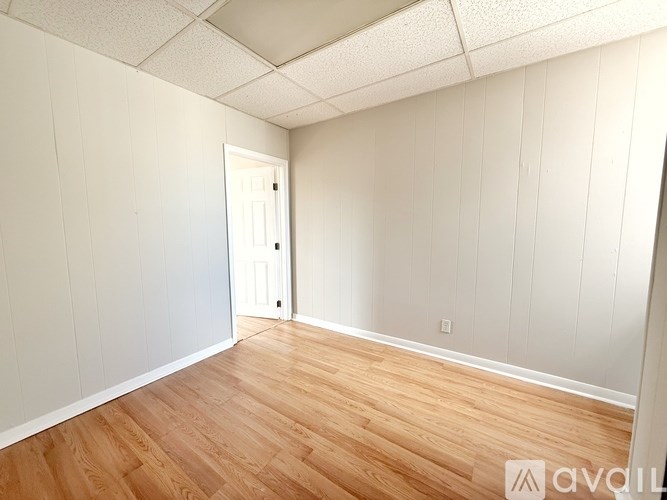 A room with wooden flooring and a white door.