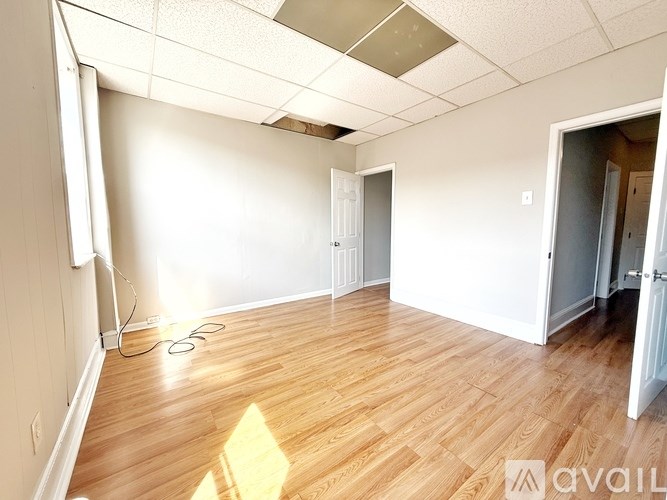 A room with wooden flooring and white walls is available for rent.