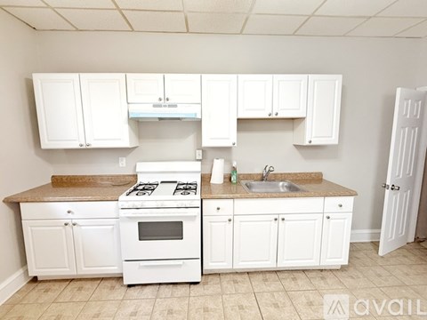 A kitchen with white cabinets and a granite countertop.