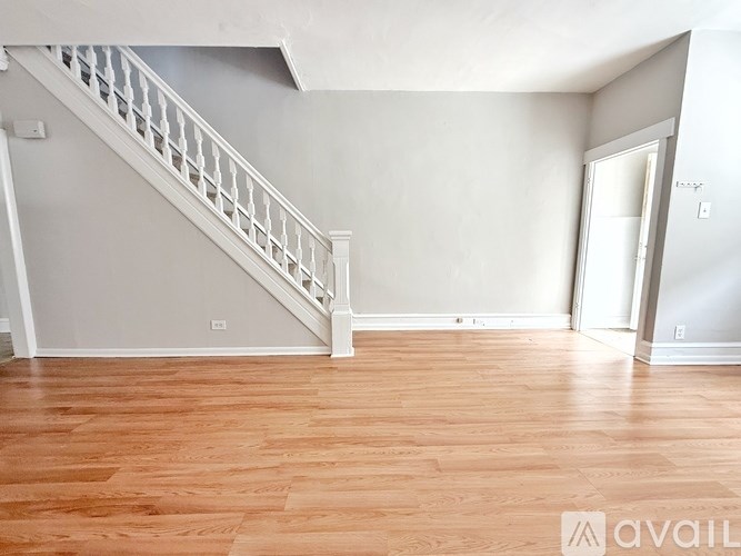 A room with wooden flooring and a staircase.