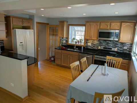 A kitchen with wooden cabinets and a black countertop.