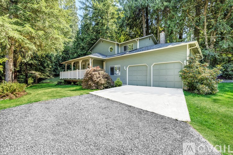 A house with a gravel driveway in front of it.