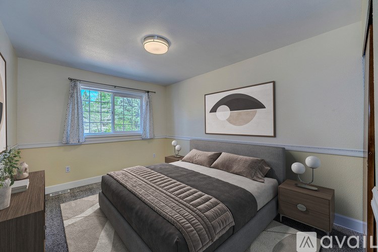 A bedroom with a bed, nightstand, and a painting on the wall.