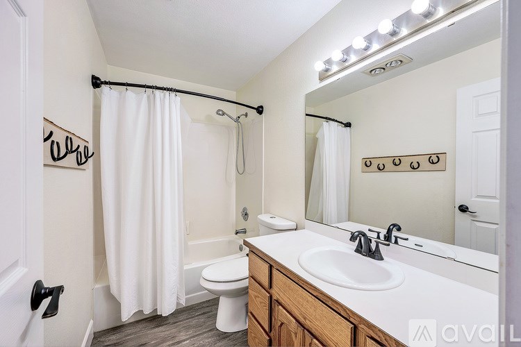 A bathroom with a white shower curtain and a white toilet.