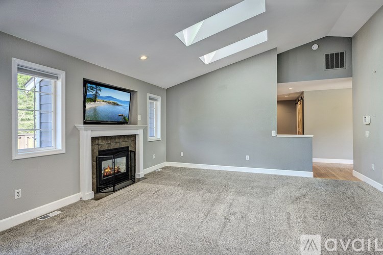 A living room with a fireplace and a television on the wall.