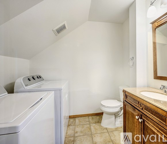 A small bathroom with a toilet, sink, and washer.