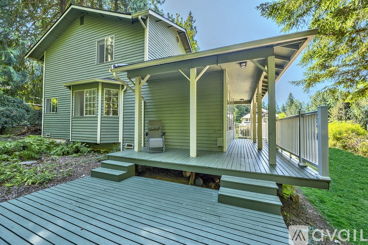 A house with a green porch and a covered patio.