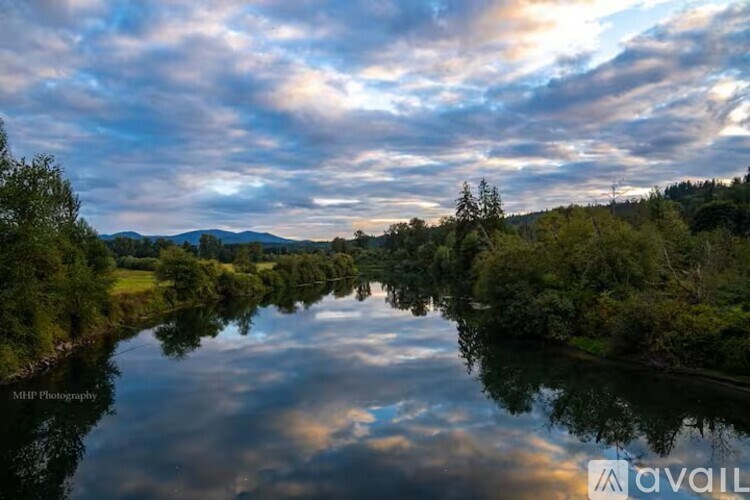 A serene landscape with a river reflecting the sky and trees on the banks.