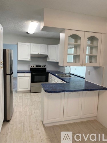 A kitchen with white cabinets and a blue countertop.