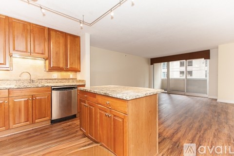 A kitchen with wooden cabinets and a marble countertop is available for rent.