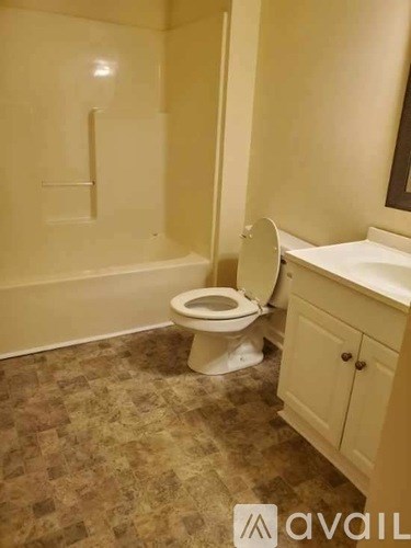 A bathroom with a toilet, sink, and bathtub.