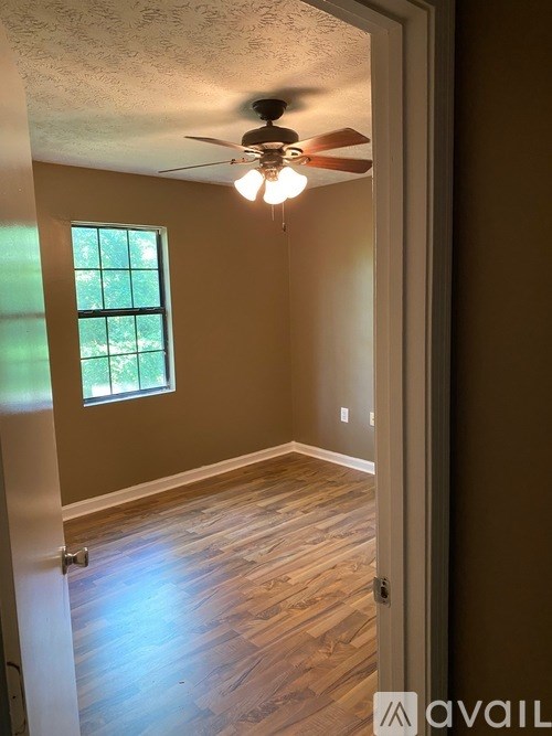A room with a ceiling fan and a window.