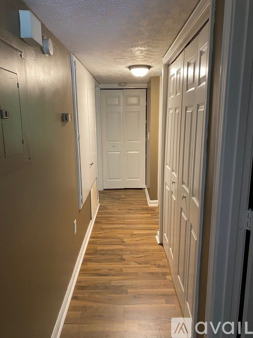 A hallway with wooden floors and white doors.