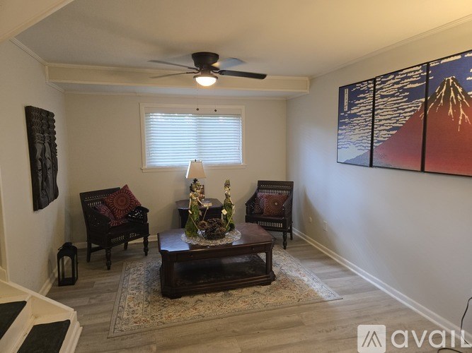 A living room with a couch, chair, and a painting of a mountain.
