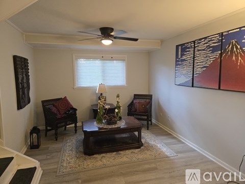 A living room with a couch, chair, and a painting of a mountain.