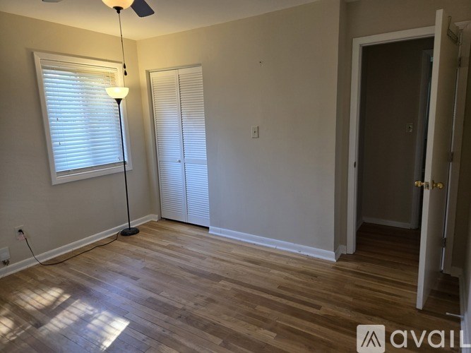 A room with wooden flooring and a ceiling fan.