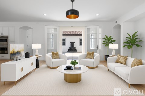 A modern living room with white furniture and a large window.