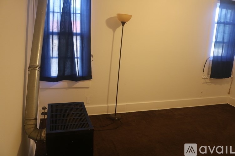 A room with a black speaker and a floor lamp.