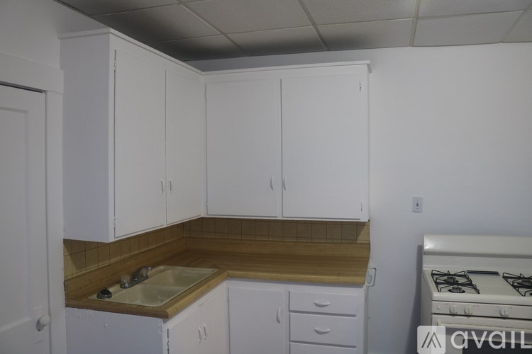 A kitchen with white cabinets and a wooden countertop.