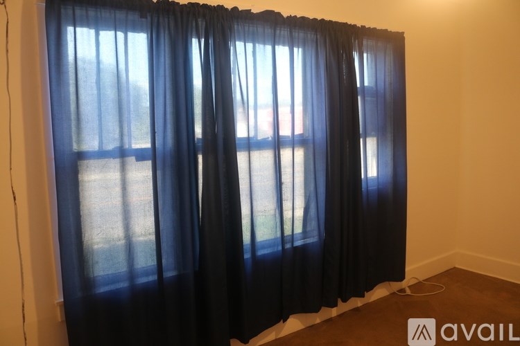 A window with a blue curtain is open.