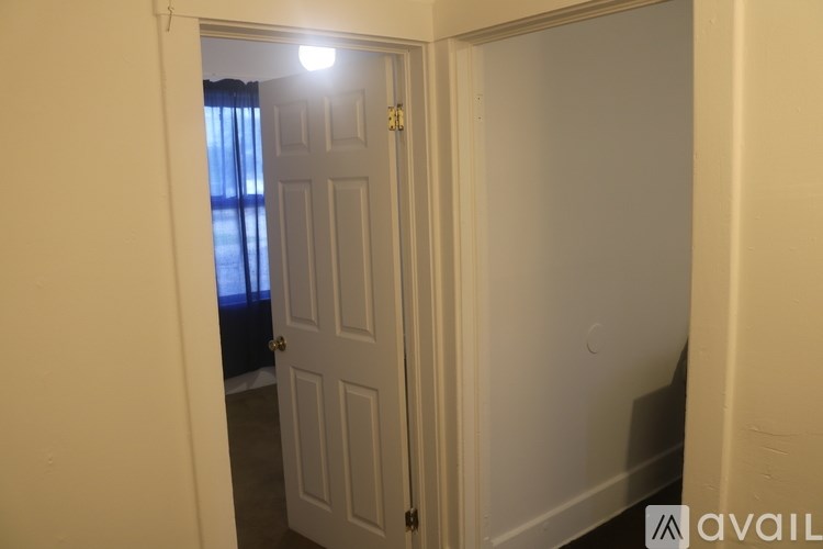 A white door is in a white room.