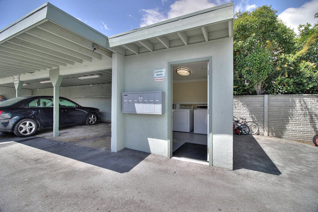 A car is parked in a garage with a white car parked inside.